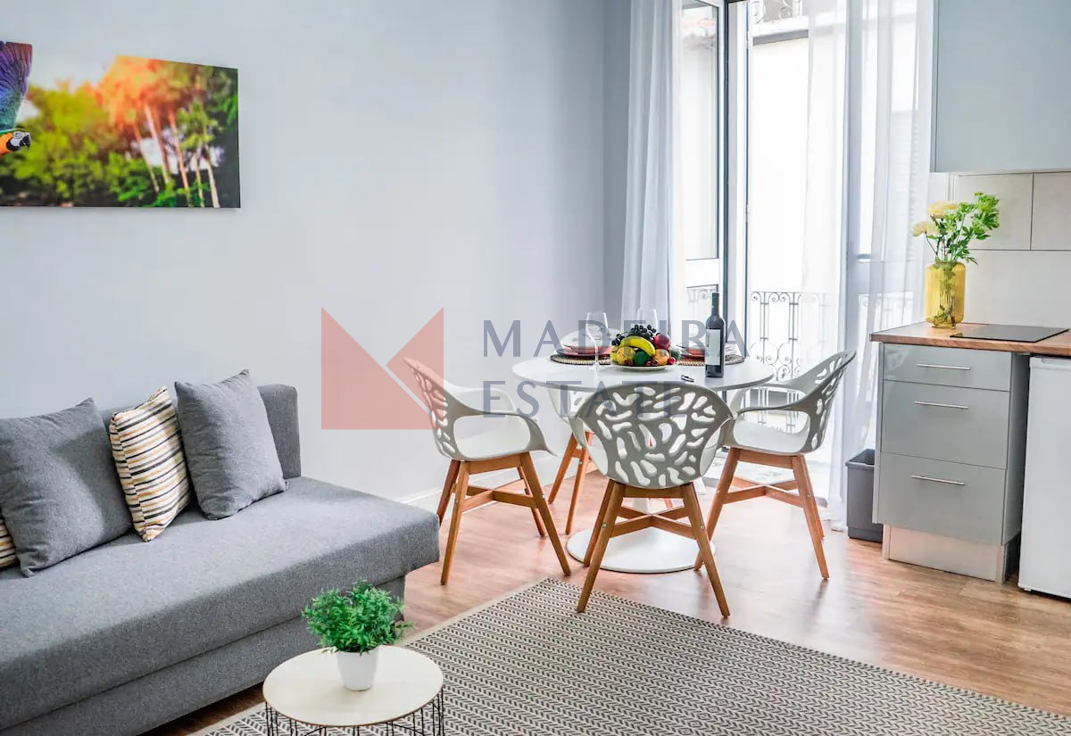 Sala de estar acolhedora com uma mesa de jantar num apartamento de aluguer de curta duração no Funchal