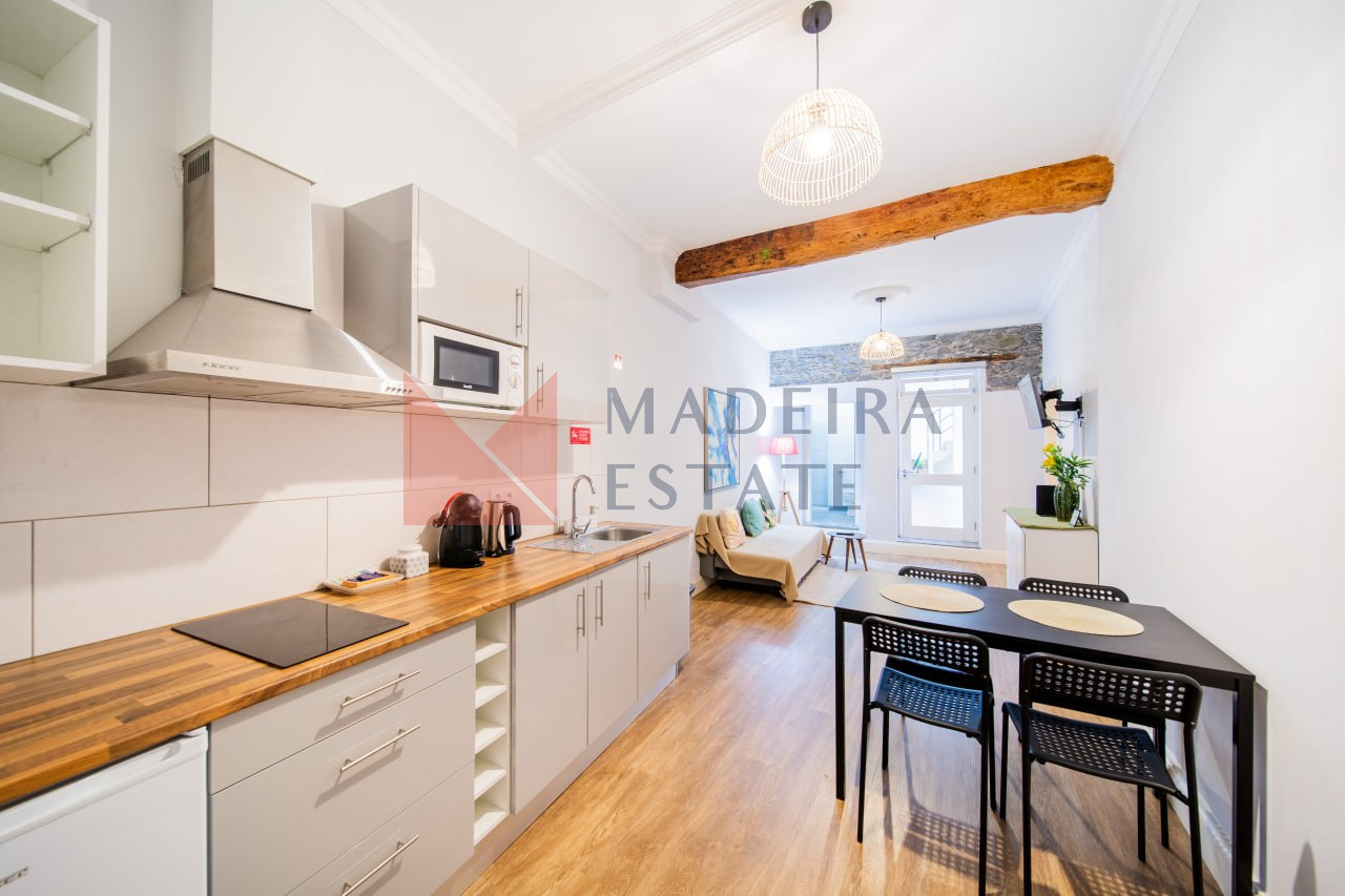 Sala de estar e cozinha em plano aberto num apartamento de aluguer de curta duração no Funchal