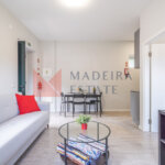 Living room with sofa, coffee table, dining table, and TV in short-term rental apartment at JMF House, São Vicente, Madeira