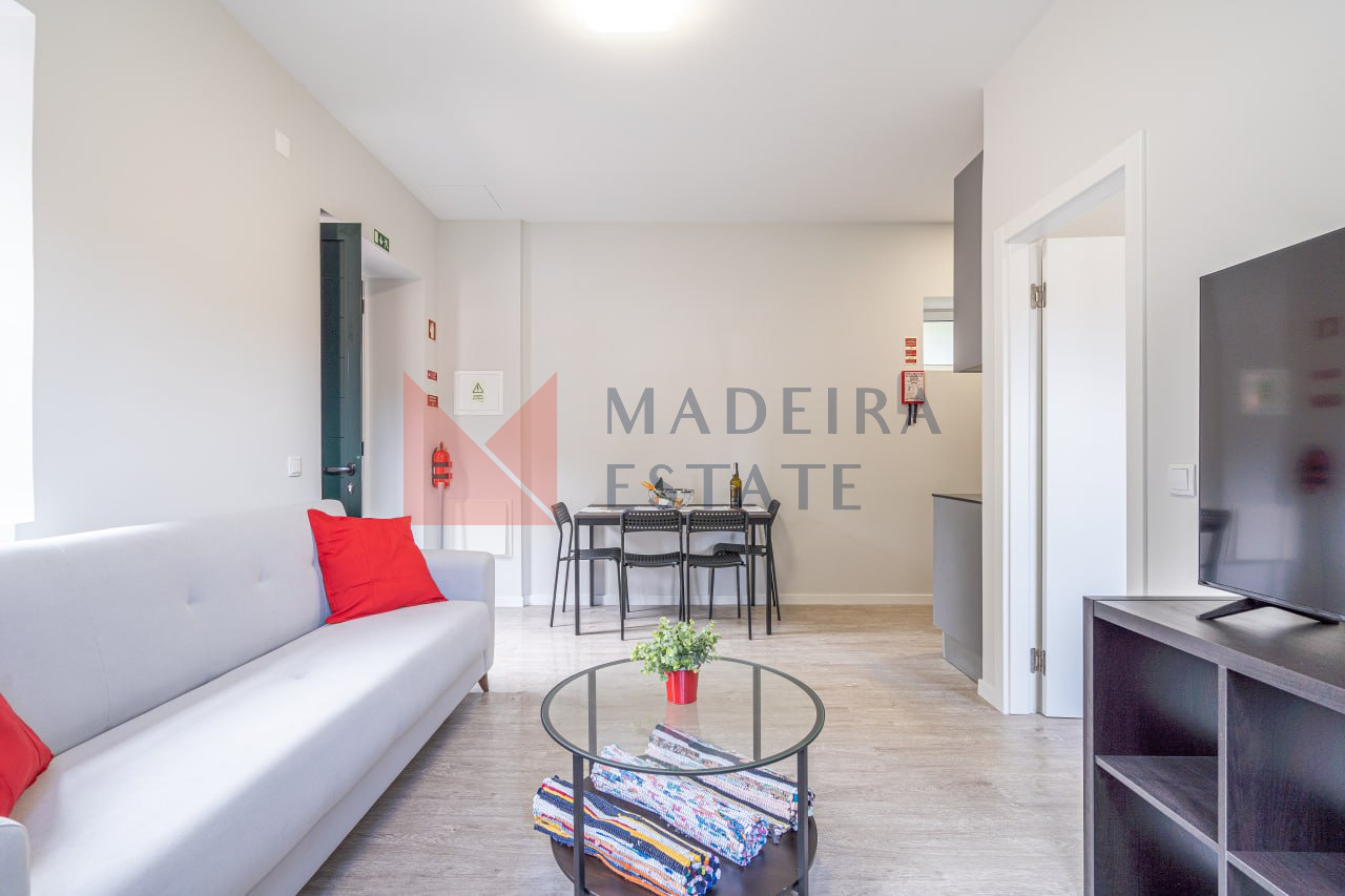Sala de estar com sofá, mesa de café, mesa de jantar e televisão no apartamento de aluguer de curta duração na JMF House, São Vicente, Madeira