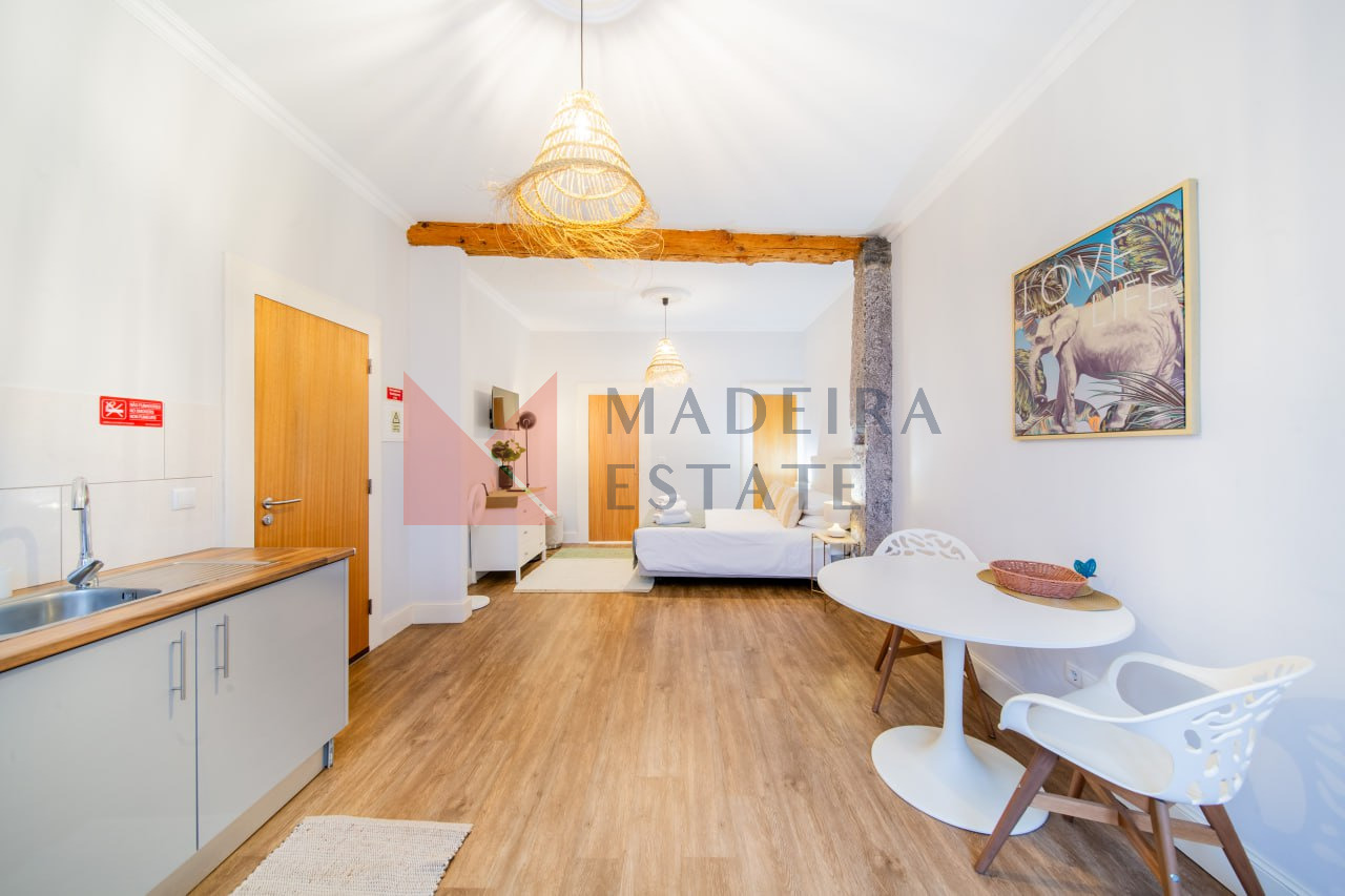 Sala de estar com uma mesa de jantar num apartamento de aluguer de curta duração no Funchal