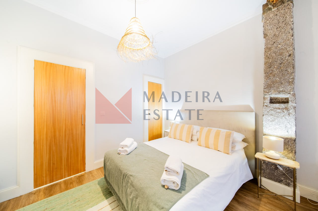 Cama de casal num acolhedor apartamento de aluguer de curta duração no Funchal