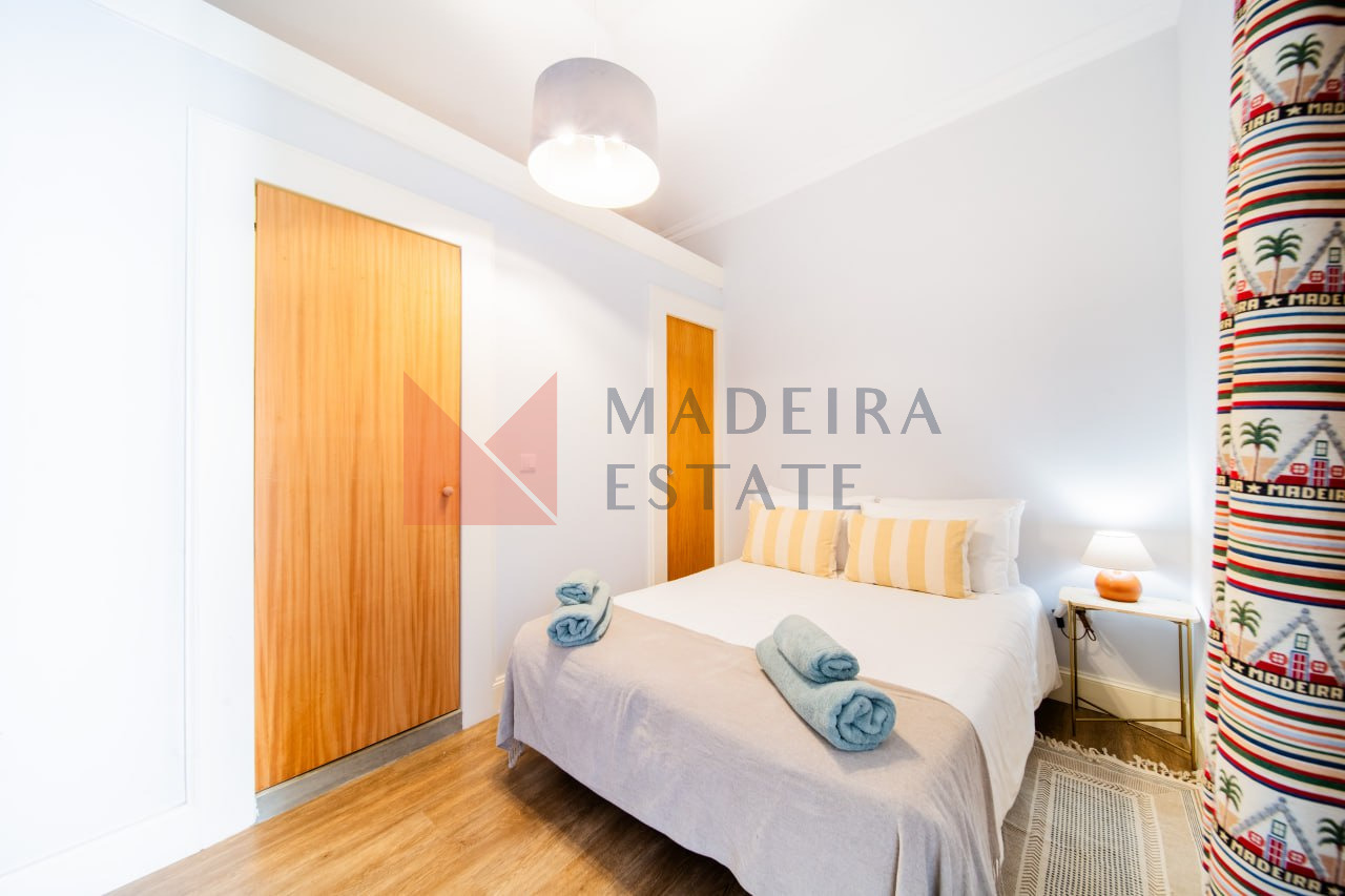 Quarto acolhedor com uma cama de casal num apartamento de aluguer de curta duração no Funchal