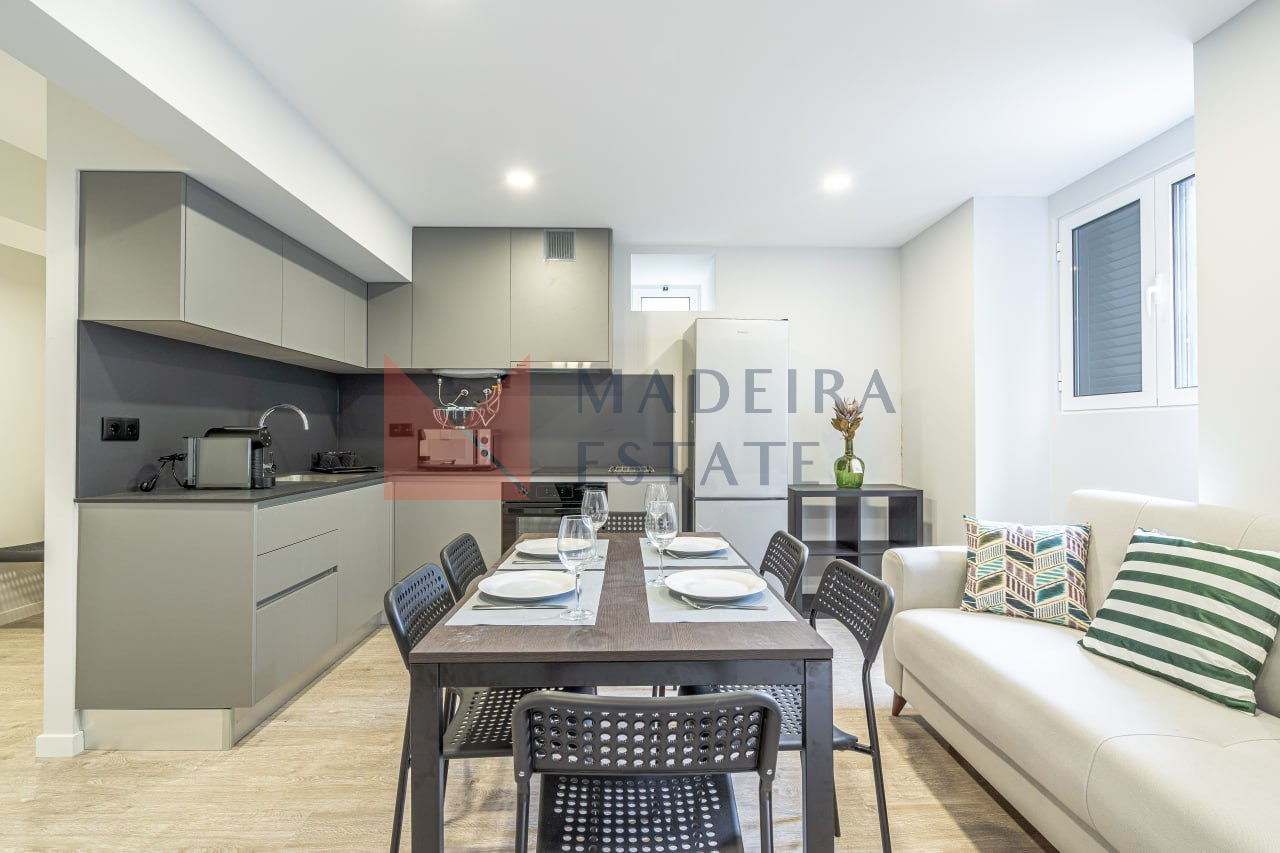Living room with dining table and open-plan kitchen in JMF House, São Vicente, Madeira