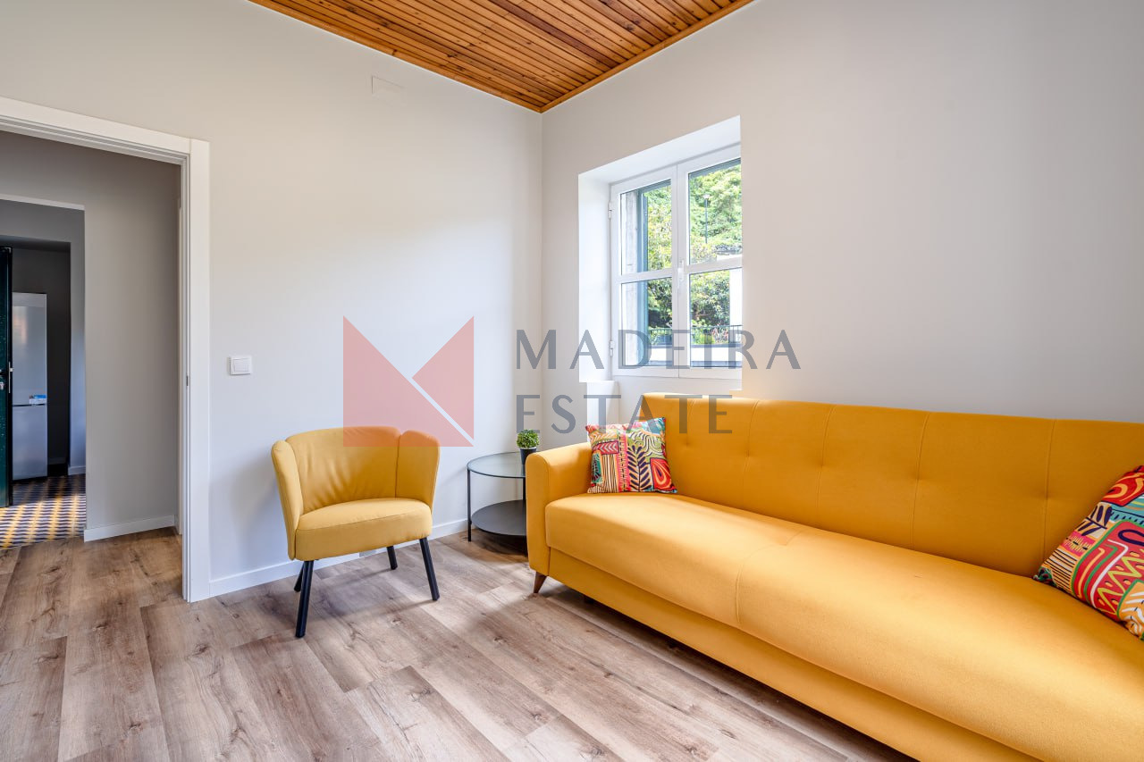 Sala de estar com sofá, poltrona e mesa de café em aluguer de curta duração na JMF House, São Vicente, Madeira