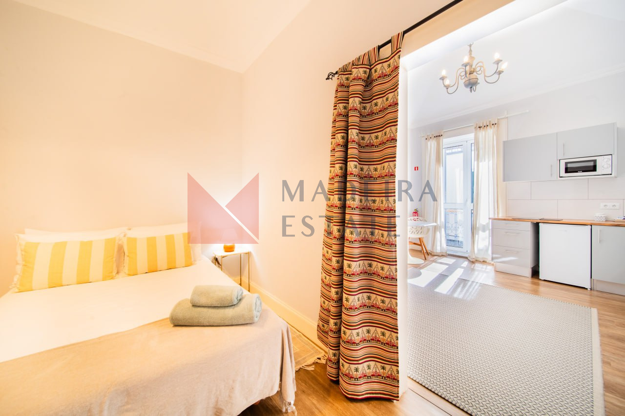 Vista combinada do quarto e da sala de estar de um apartamento de aluguer de curta duração no Funchal