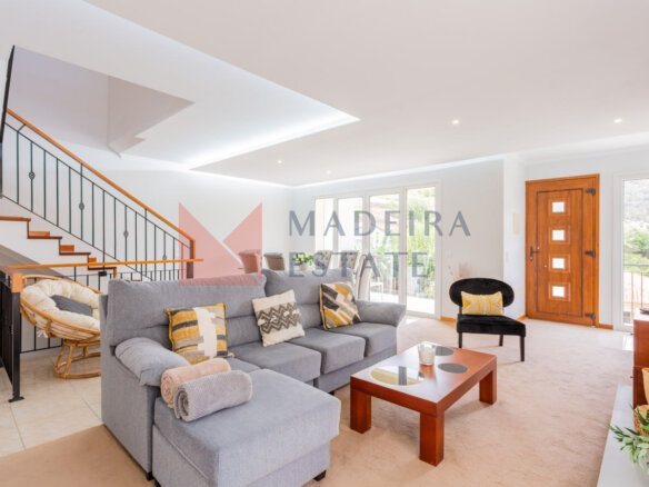 Bright living room in vacation rental home in Madeira with panoramic windows, sofa, coffee table, and armchairs