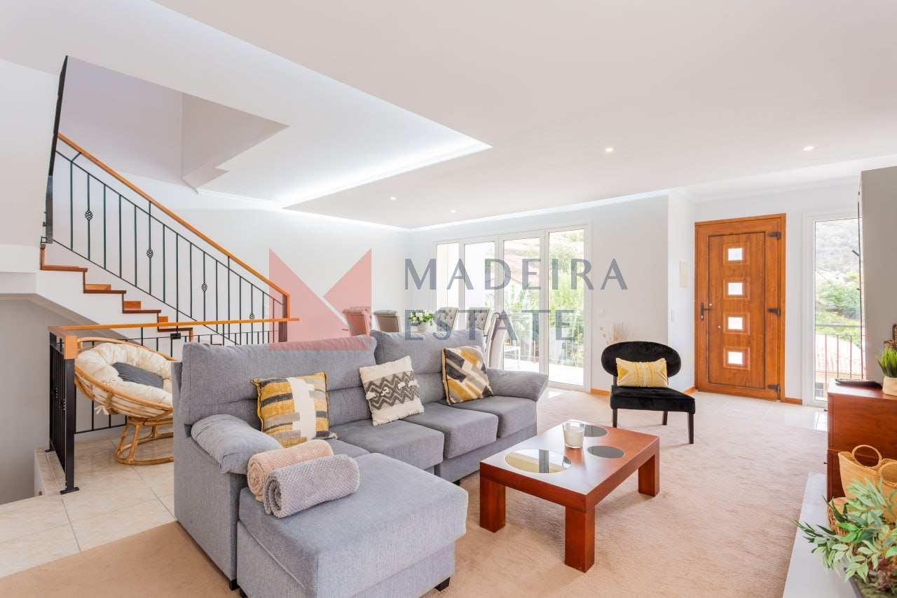 Bright living room in vacation rental home in Madeira with panoramic windows, sofa, coffee table, and armchairs