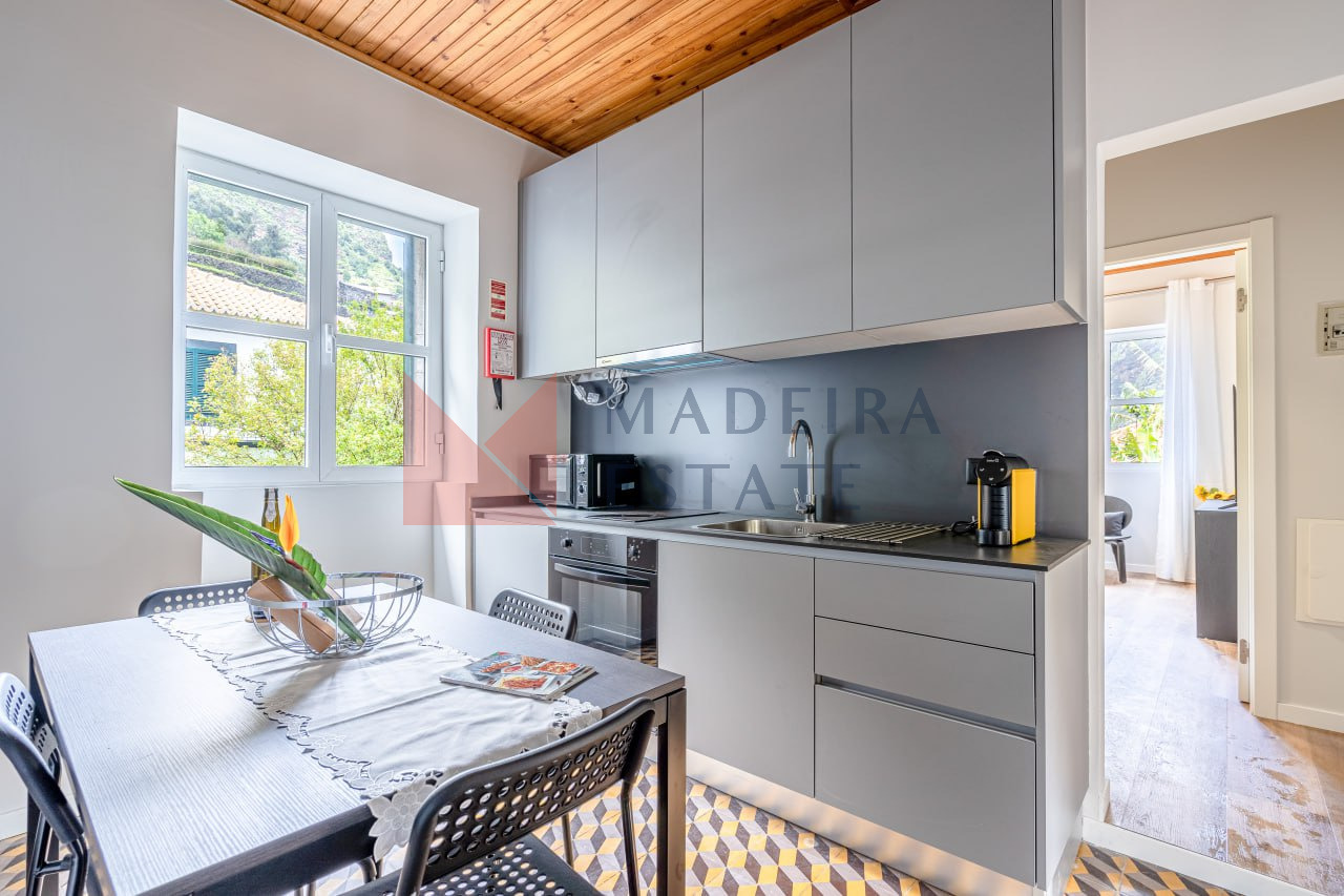 Cozinha totalmente equipada com micro-ondas, máquina de café, forno e mesa de jantar na JMF House, São Vicente, Madeira