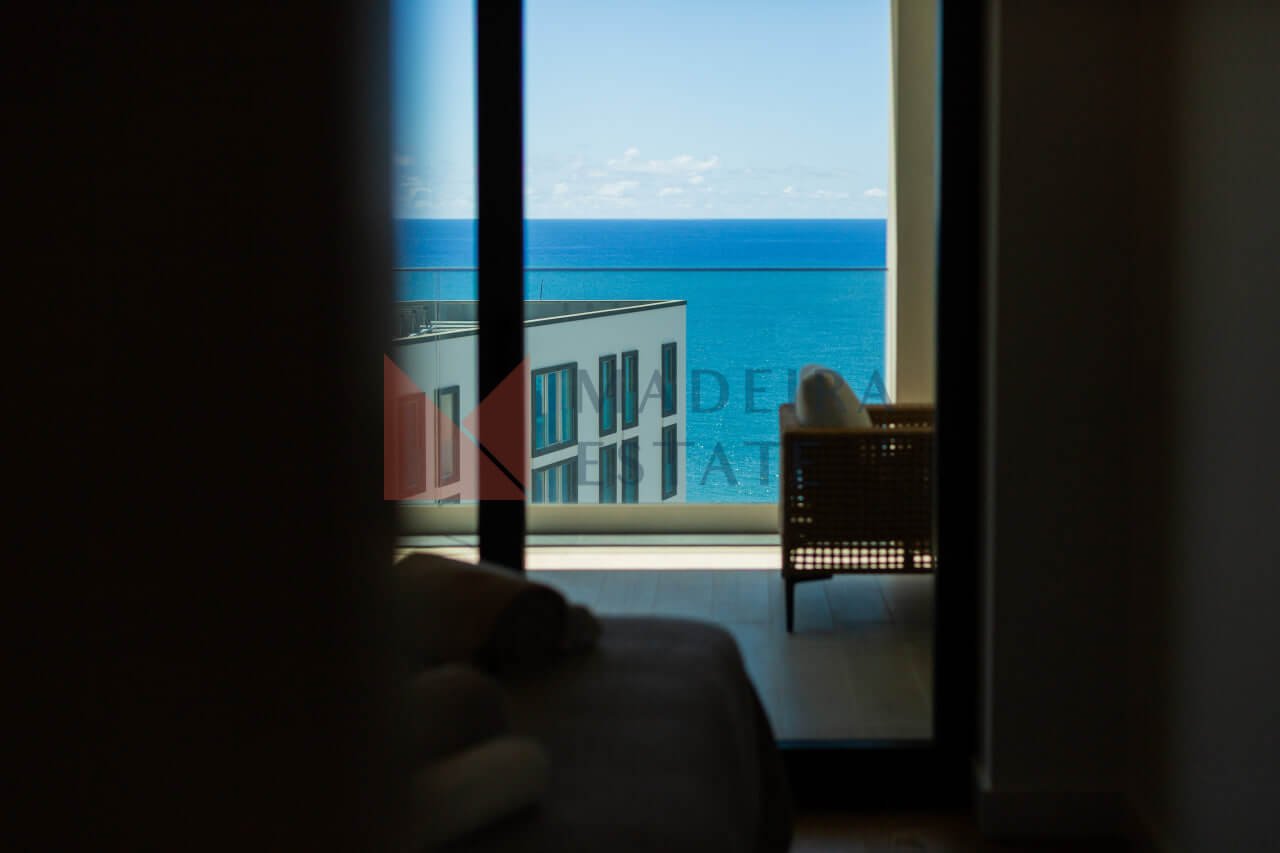 Window with balcony access and ocean view in Funchal short-term rental apartment