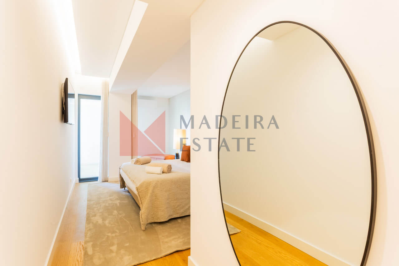 Entrance to bedroom with decorative mirror in Funchal short-term rental apartment