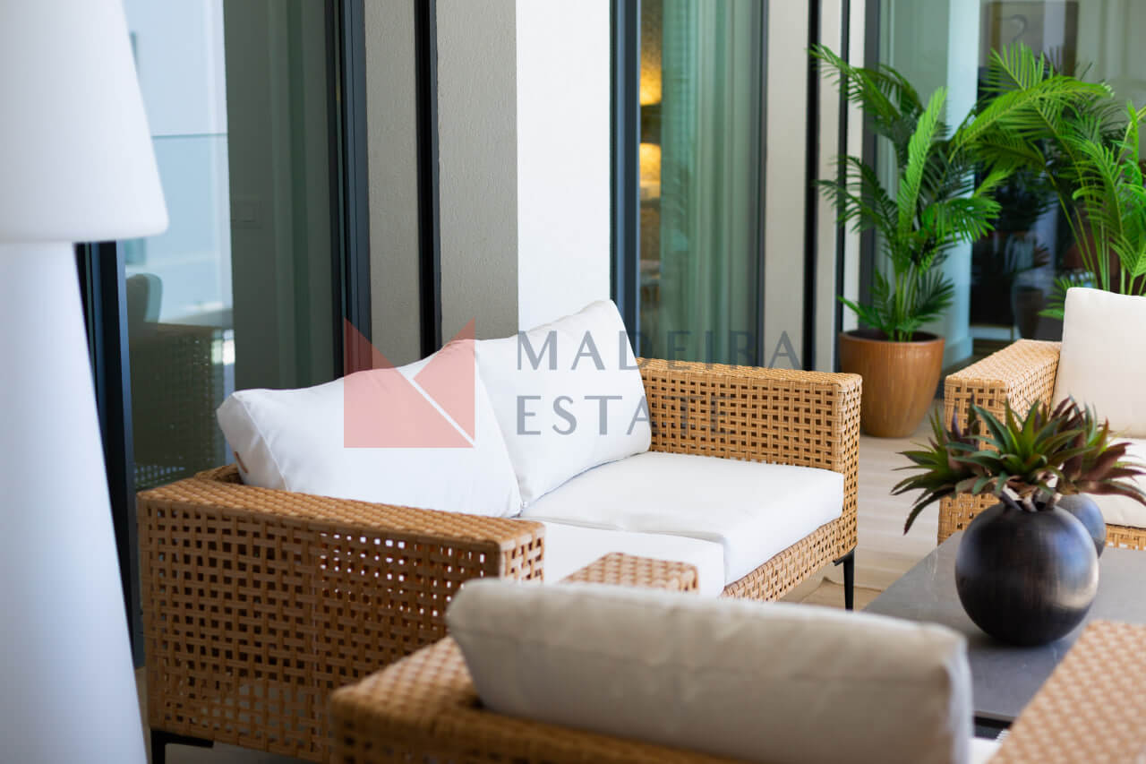 Sofa and armchair on balcony with ocean view in Funchal short-term rental apartment