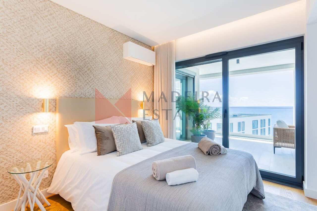 Double bedroom with panoramic window and ocean view in Funchal short-term rental apartment