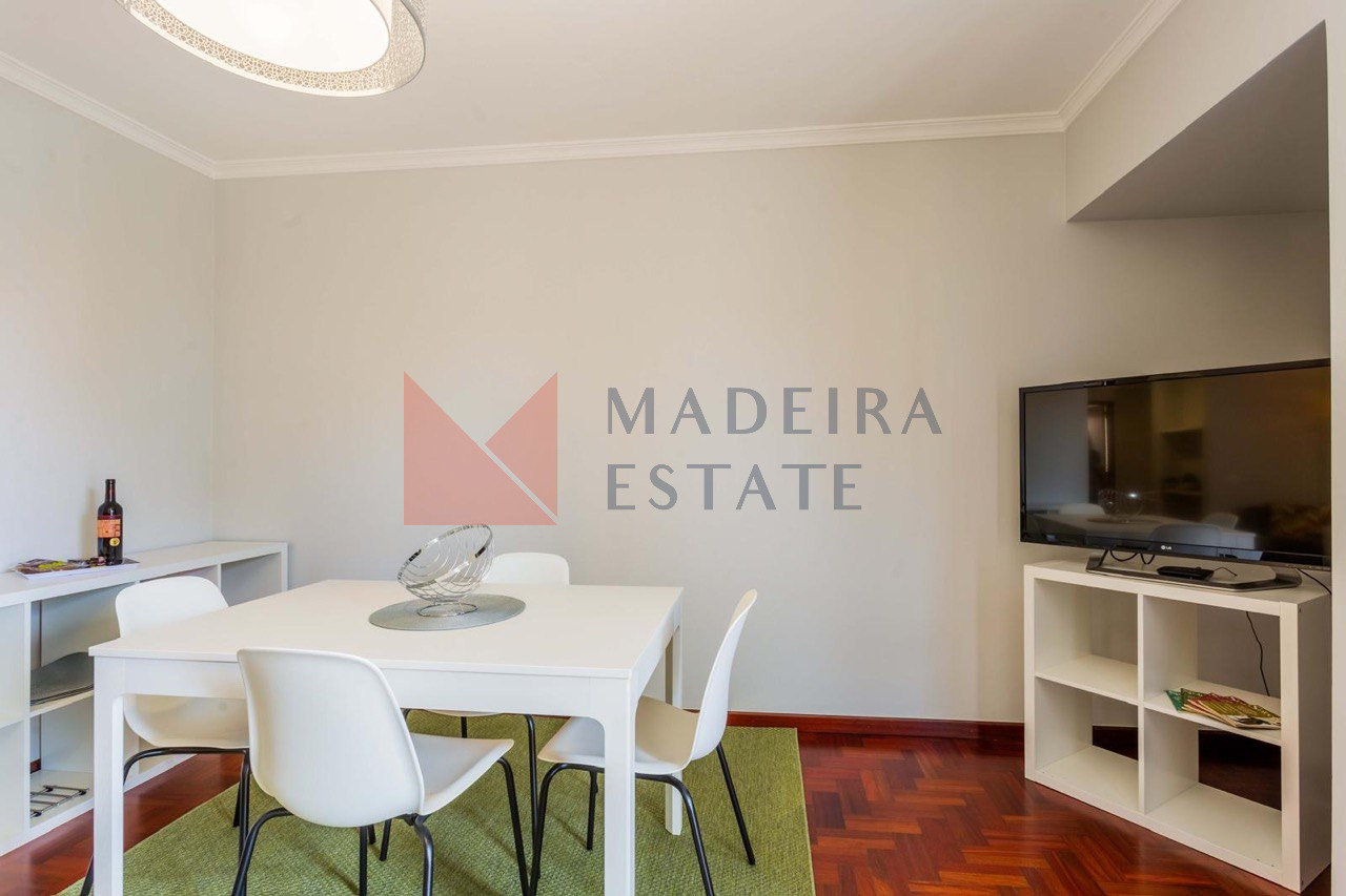 Living Room with Dining Area and TV – JMF Apartment, Funchal, Madeira Living room with parquet floor, dining table for four, and TV – JMF Apartment, Madeira short-term rental