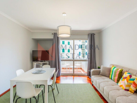 Bright living room with parquet floor, sofa, dining table, TV, and balcony access – JMF Apartment, Madeira short-term rental